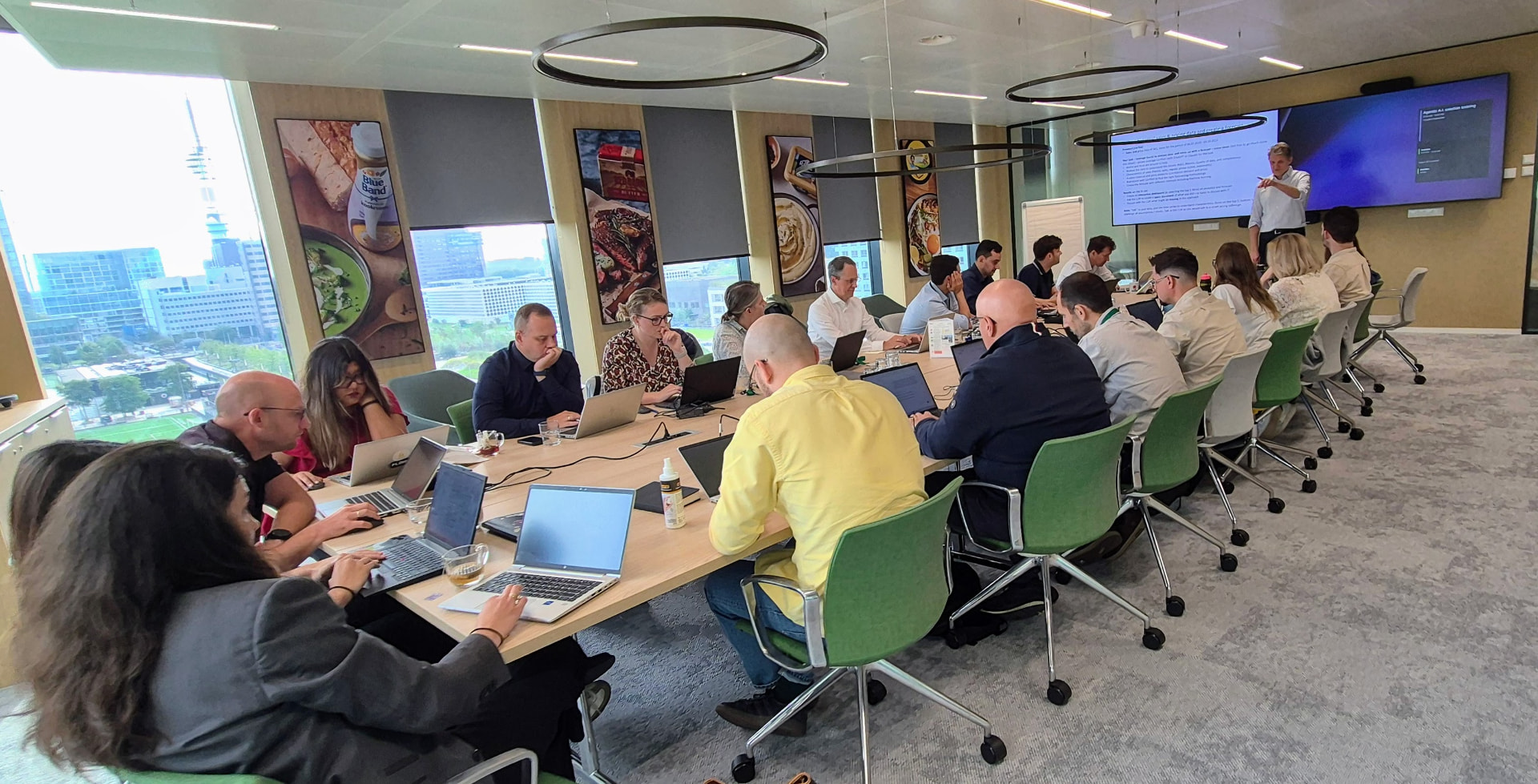 A full workshop room with supply-chain and operations leaders working on laptops.